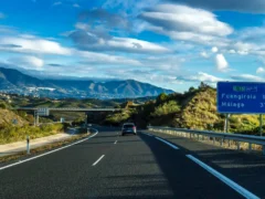 Snelweg AP-7 bij Fuengirola met bergen en een blauw verkeersbord