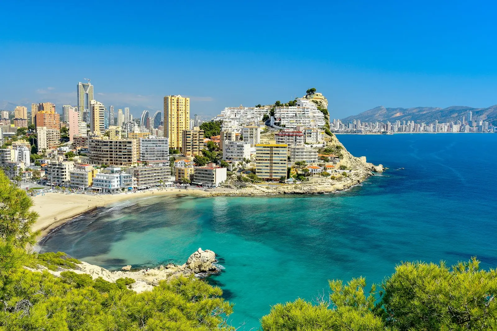 Kleine baai met turquoise water onder de rots van het oude Benidorm