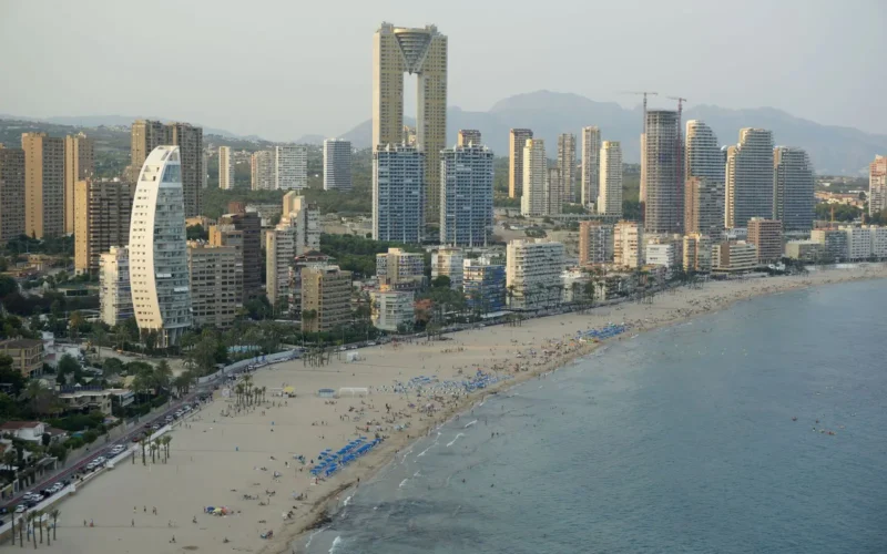 Luchtfoto van het drukke strand van Benidorm met hoge torens langs de boulevard