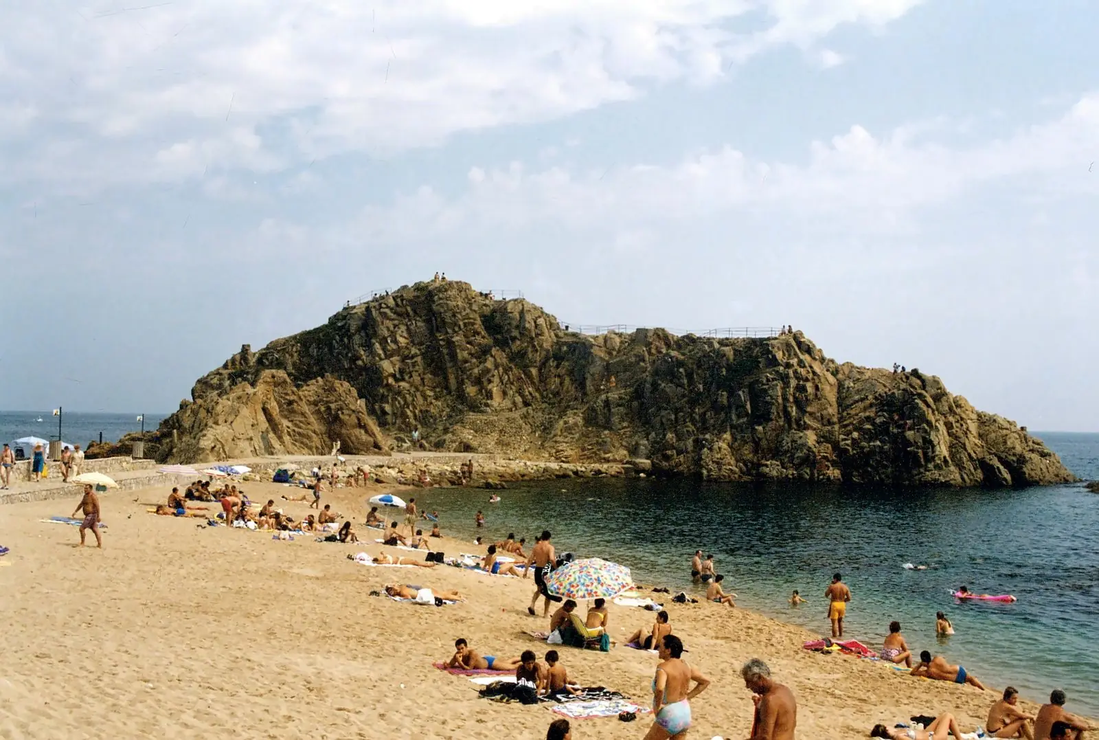 Druk strand bij de grote rots Sa Palomera in Blanes