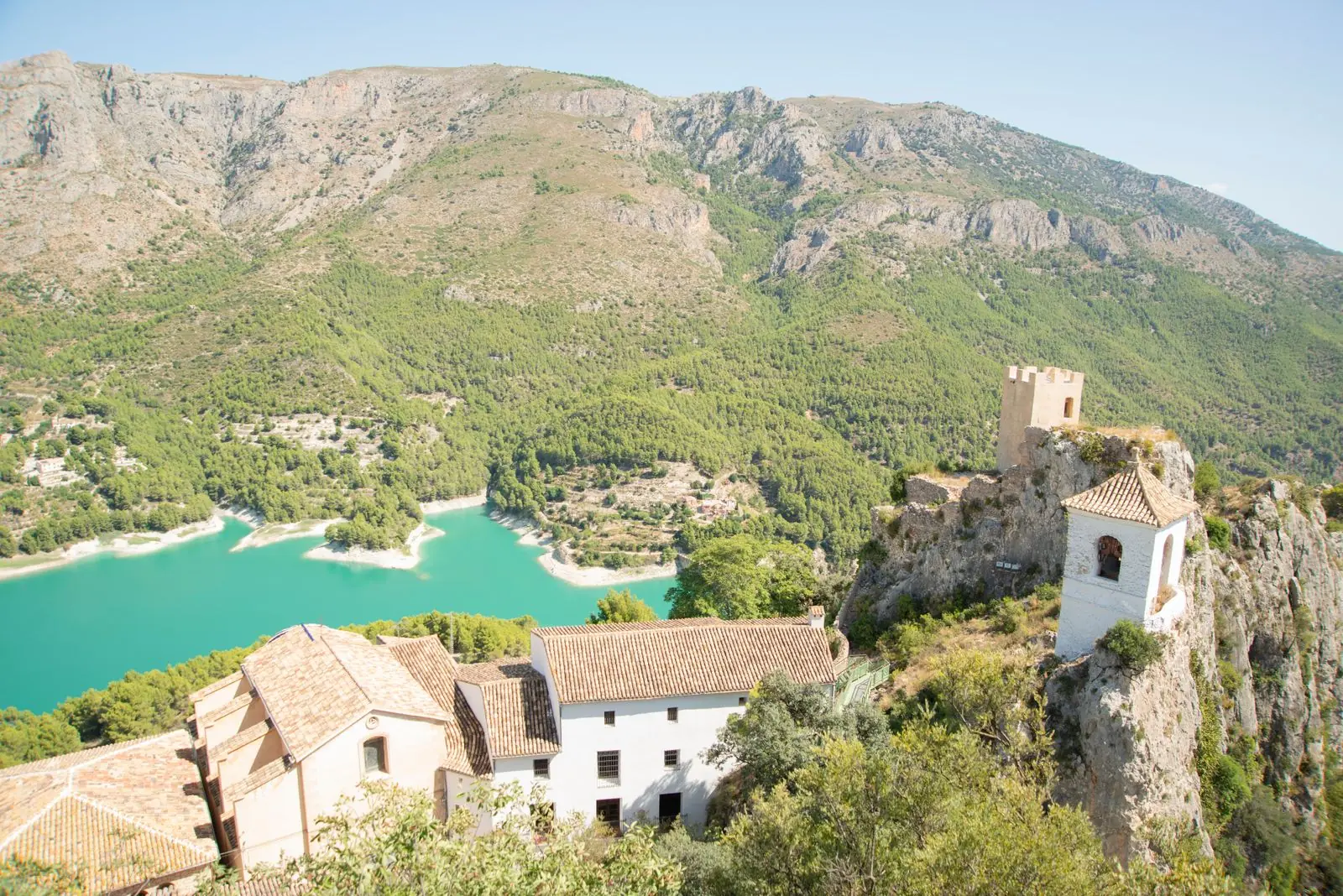 Kasteel en witte huizen van Guadalest boven een turquoise stuwmeer