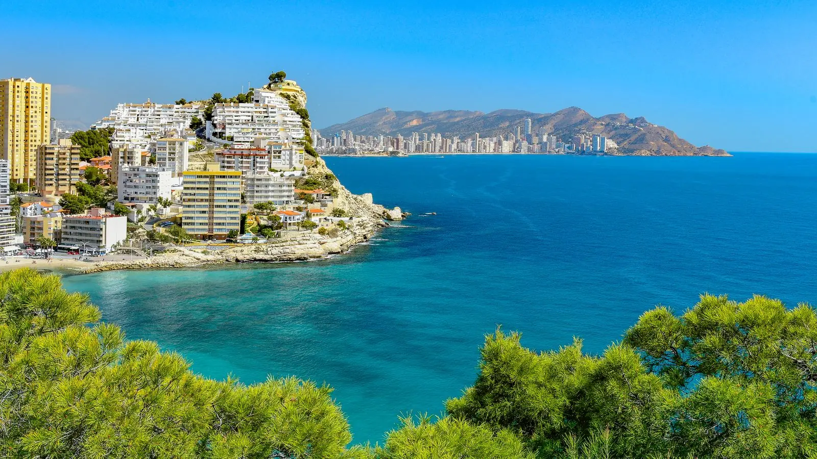 Kust van de Costa Blanca met hoogbouw en een groene rotspunt