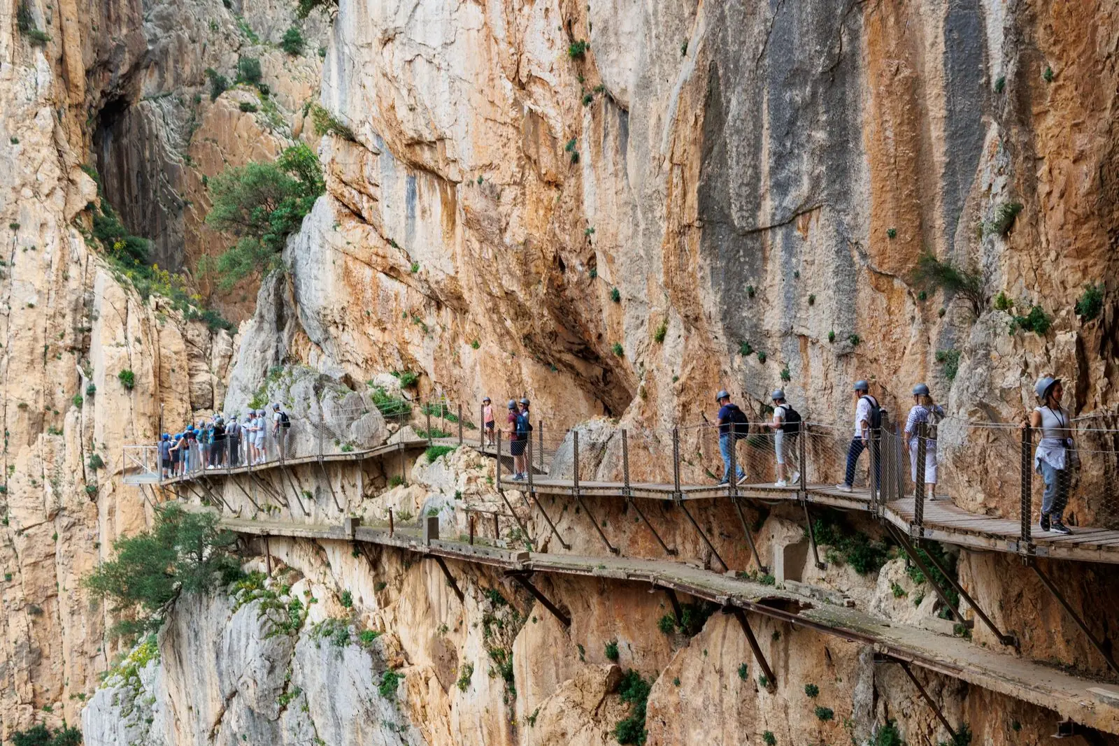 Wandelaars op de houten vlonders van het Caminito del Rey langs een rotswand