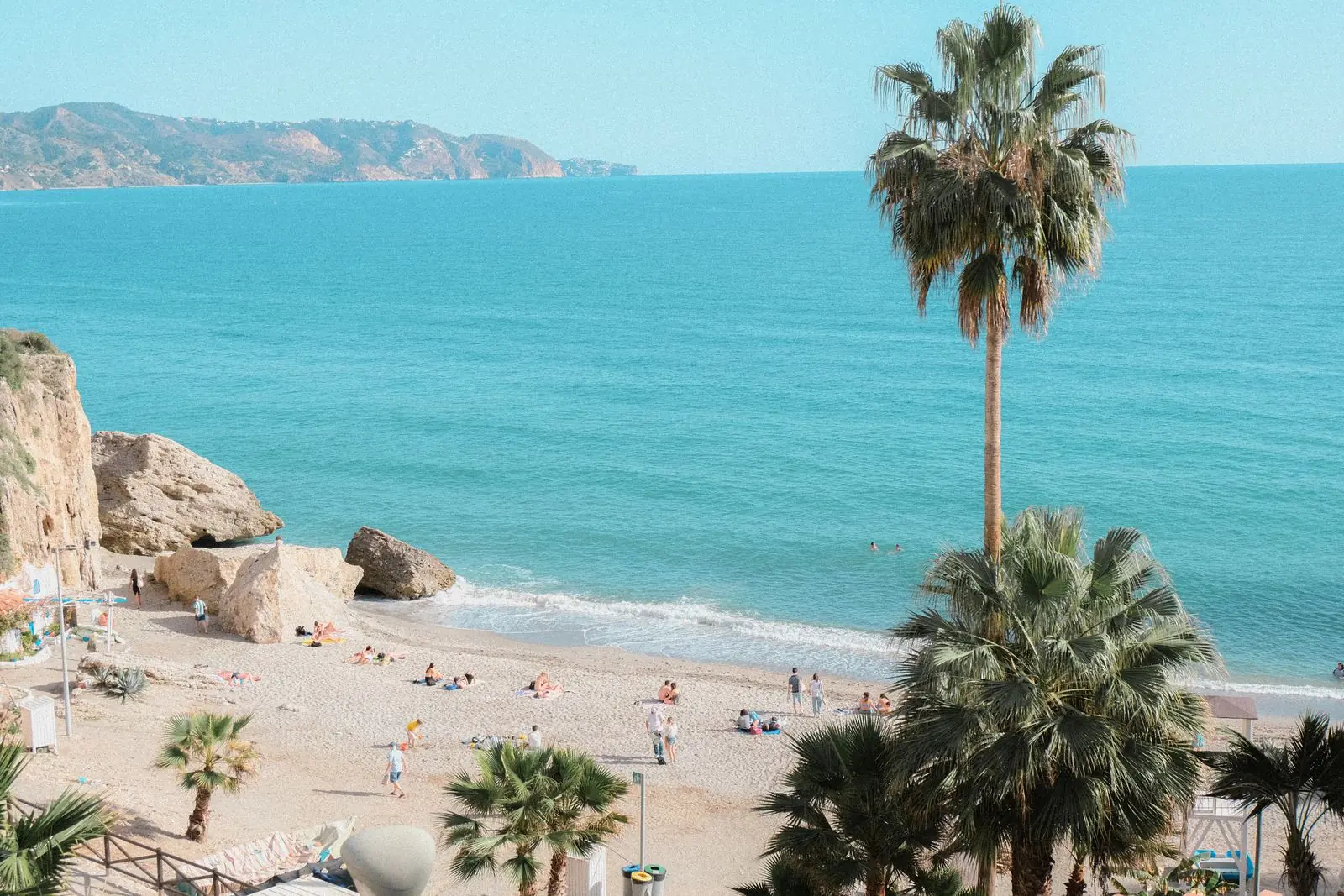 Strand van Nerja met palmbomen en blauwe zee