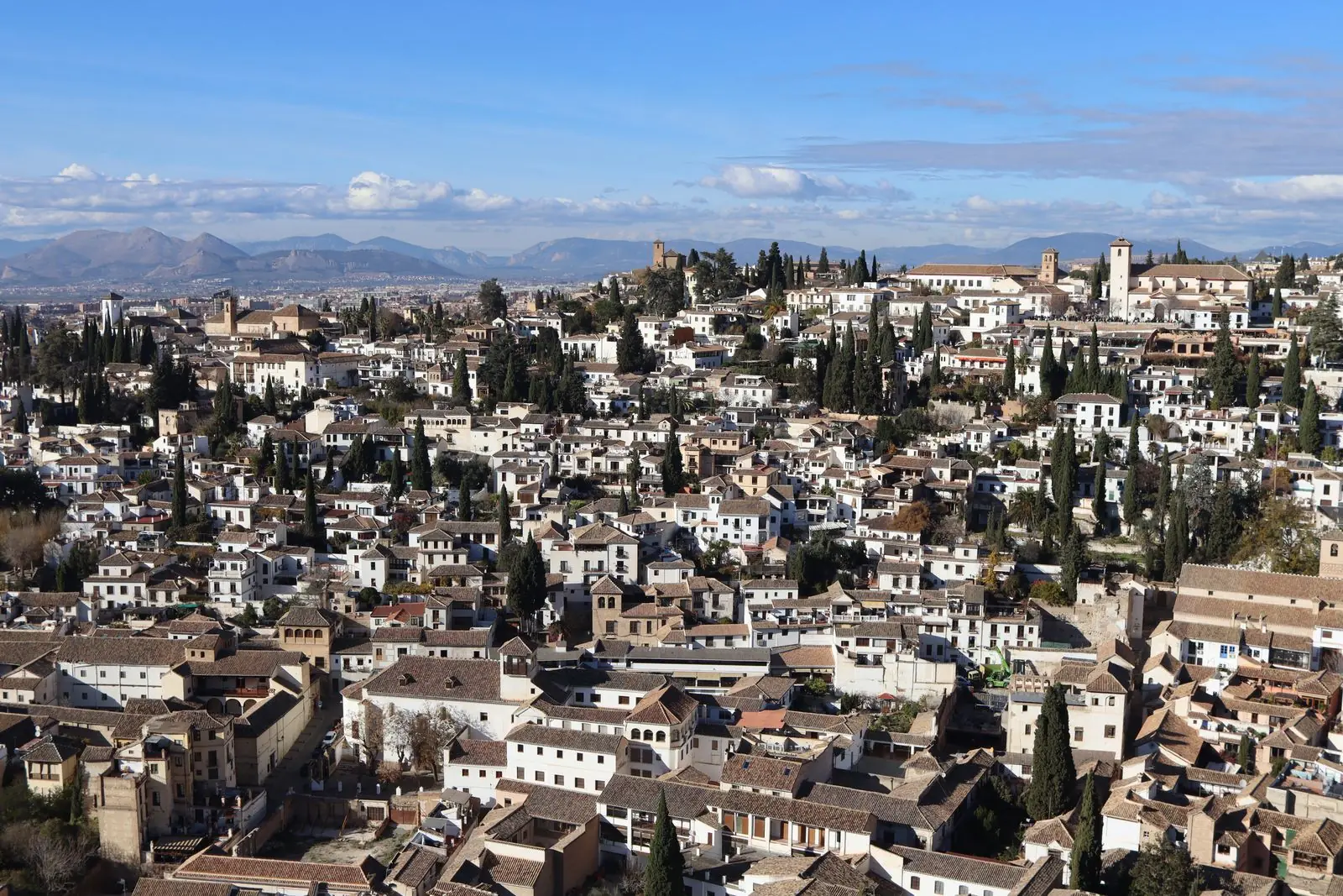 Witte huizen en cipressen van de wijk Albaicín in Granada