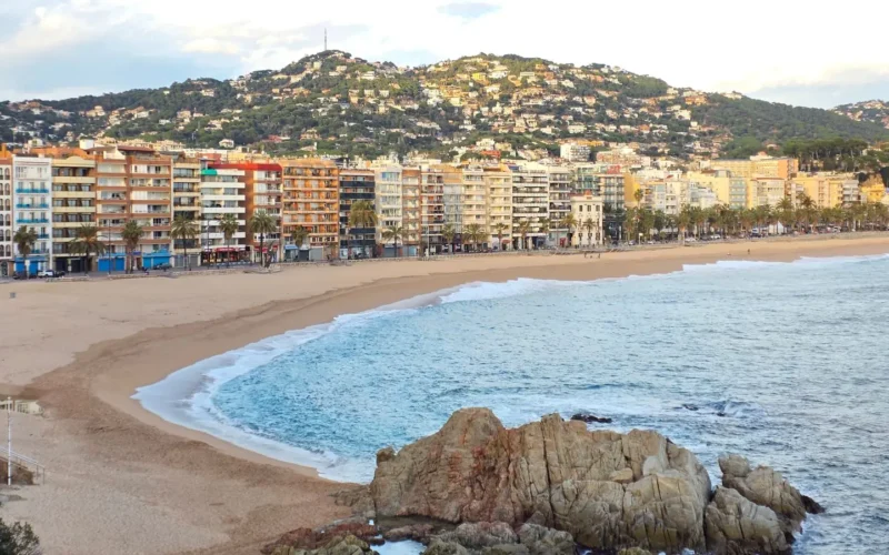 Strand van Lloret de Mar met boulevard, hotels en heuvels