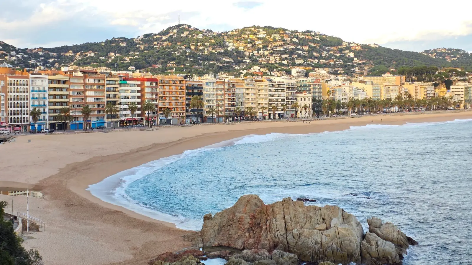 Strand van Lloret de Mar met boulevard, hotels en heuvels