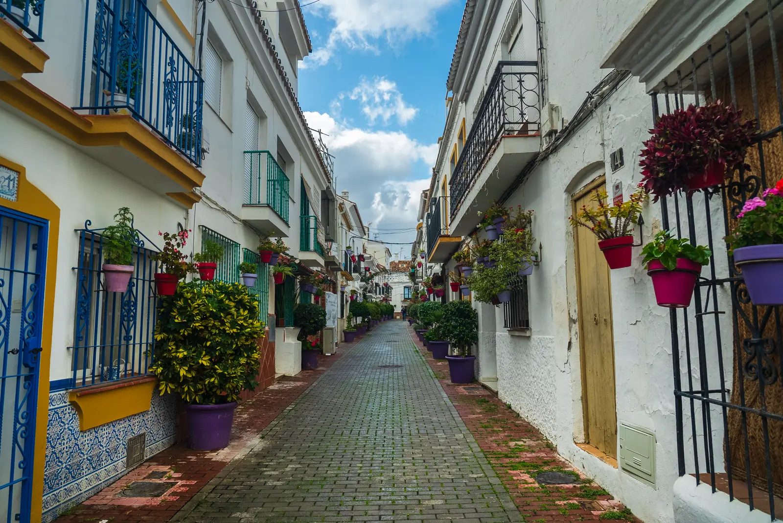 Smal straatje met witte huizen en bloempotten in het oude centrum van Marbella