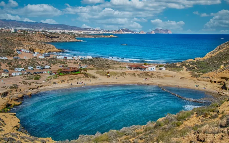 Ronde baai met helderblauw water aan de droge kust bij Mazarrón