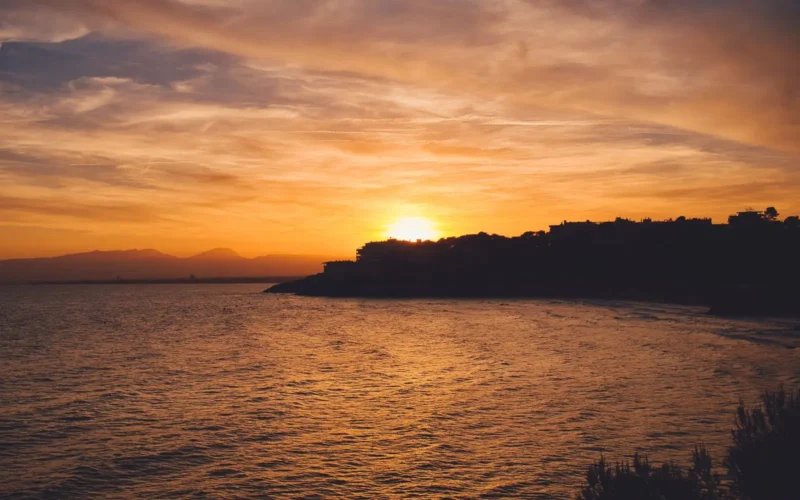 Zonsondergang boven de kust van Salou met silhouet van de landtong
