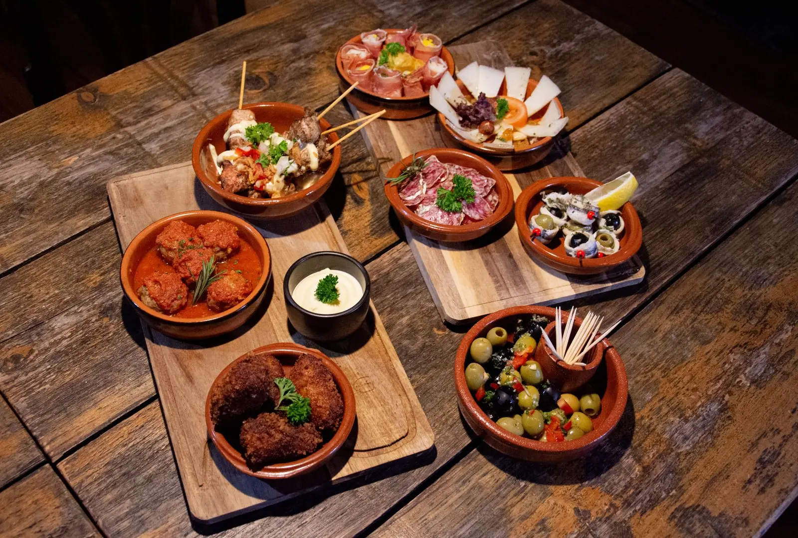 Aardewerken schaaltjes met Spaanse tapas op een houten tafel