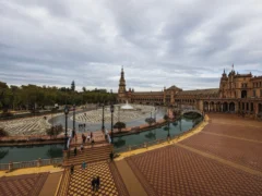 Plaza de España in Sevilla met kanaal en toren onder bewolkte lucht