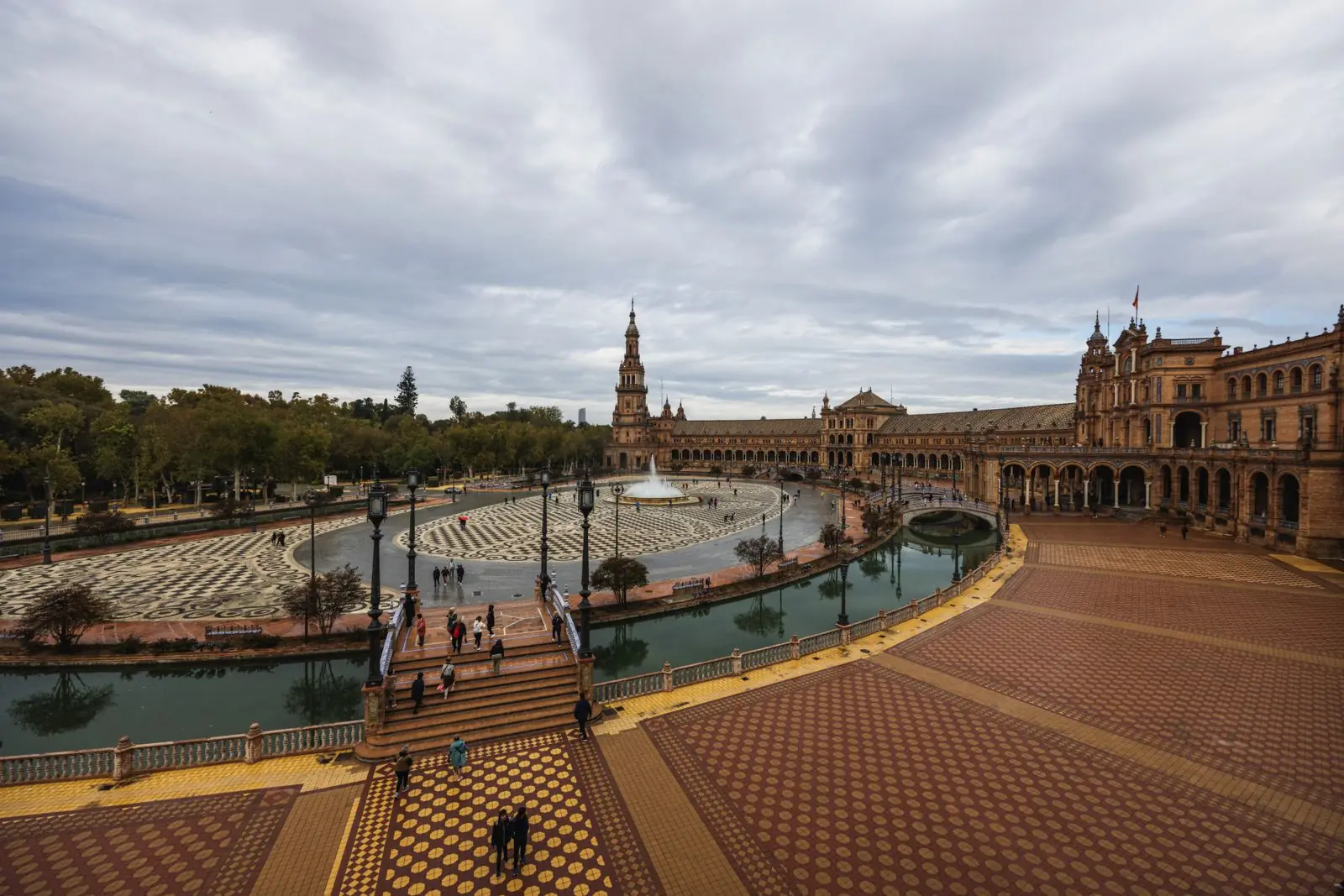 Plaza de España in Sevilla met kanaal en toren onder bewolkte lucht