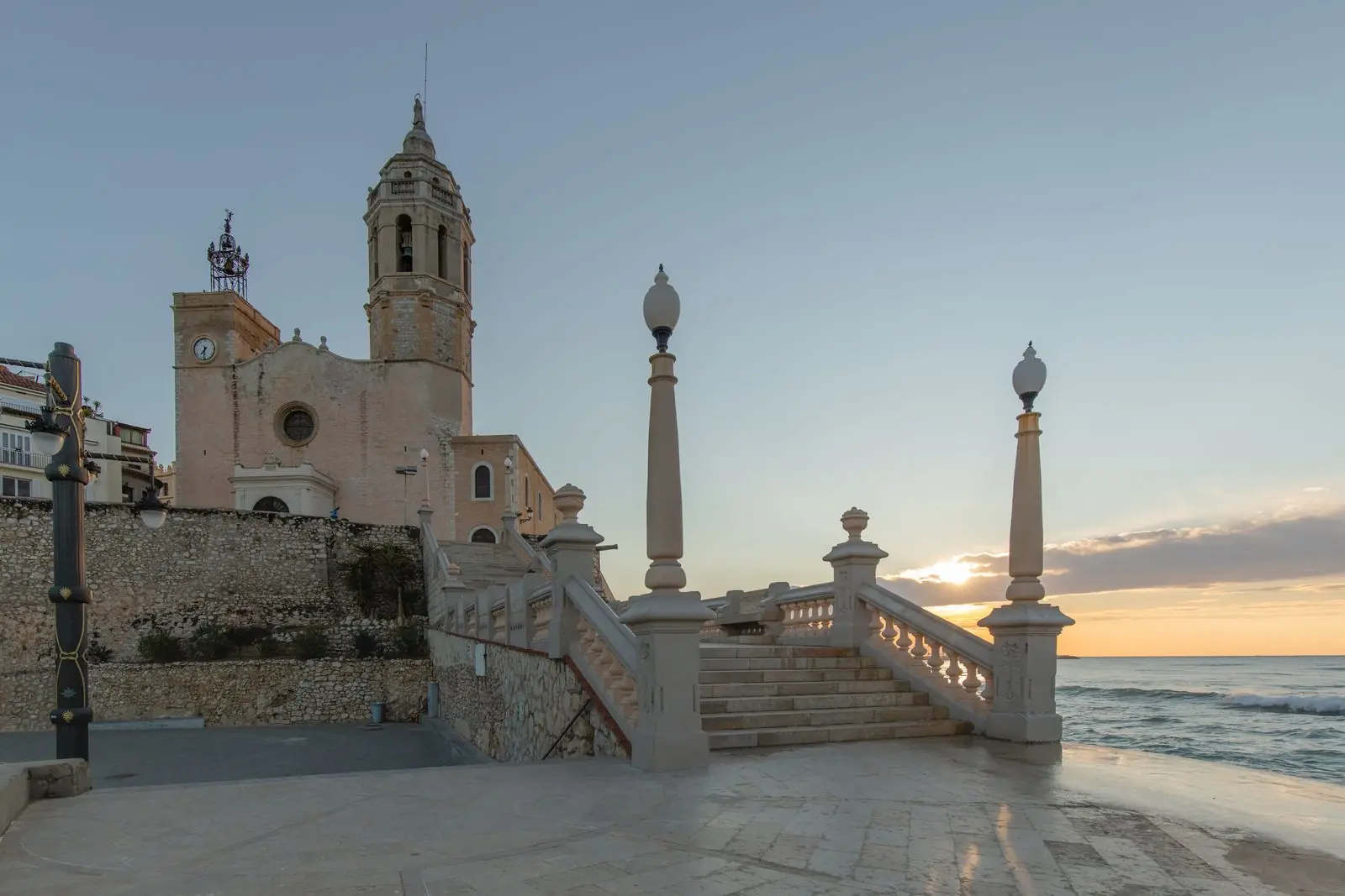 Kerk van Sant Bartomeu i Santa Tecla met trappen en balustrade bij zee