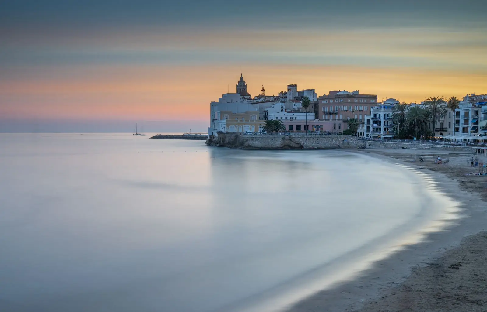 Strand van Sitges bij schemering met de kerk op de rots